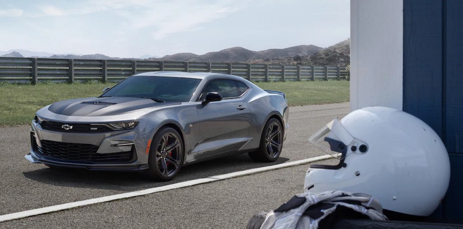 A gray 2021 Chevrolet Camaro SS 1LE on a track with a white helmet in the foreground