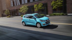 a bright blue 2021 Chevy Spark hatchback on a city street