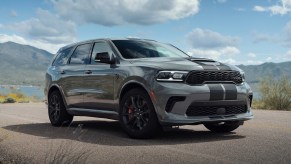 A gray-with-black-stripes 2021 Dodge Durango SRT Hellcat parked by a mountain lake