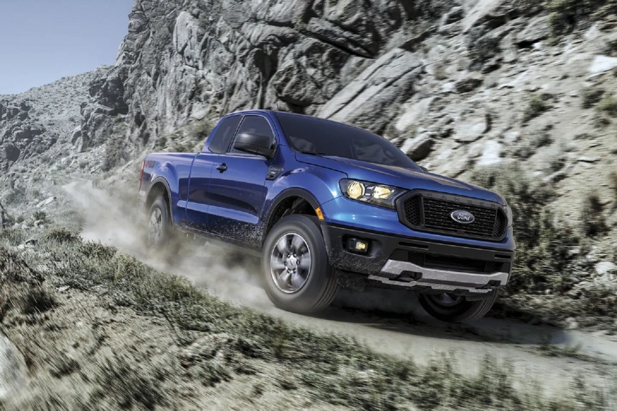 A blue 2021 Ford Ranger XLT SuperCab FX4 drives down a mountainside gravel road