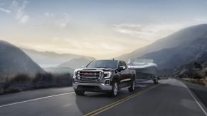 2021 GMC Sierra 1500 towing a boat down a winding road