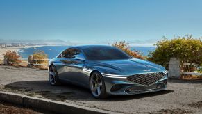 The green 2021 Genesis X Concept parked overlooking a sandy beach