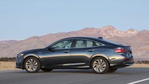 A black Honda Insight hybrid sedan parked in front of a mountain vista