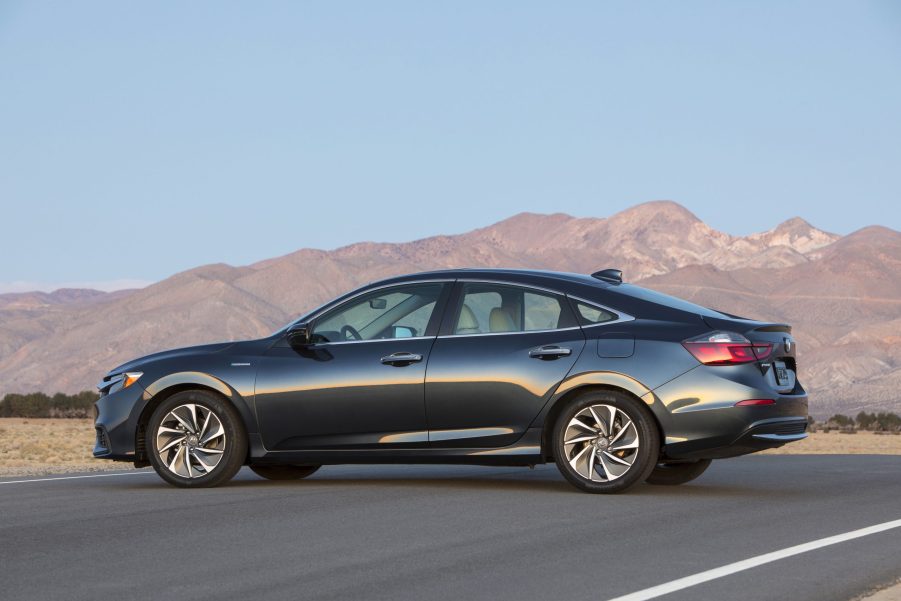 A black Honda Insight hybrid sedan parked in front of a mountain vista