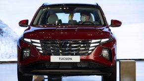 A customer wearing a protective mask sits inside a red Hyundai SUV – the Hyundai Tucson – on display at the company's Motorstudio showroom in Goyang, South Korea