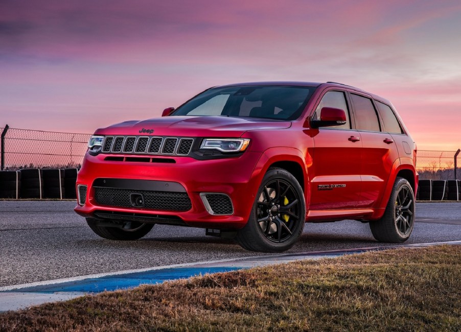 A red 2021 Jeep Grand Cherokee Trackhawk on a racetrack at sunset