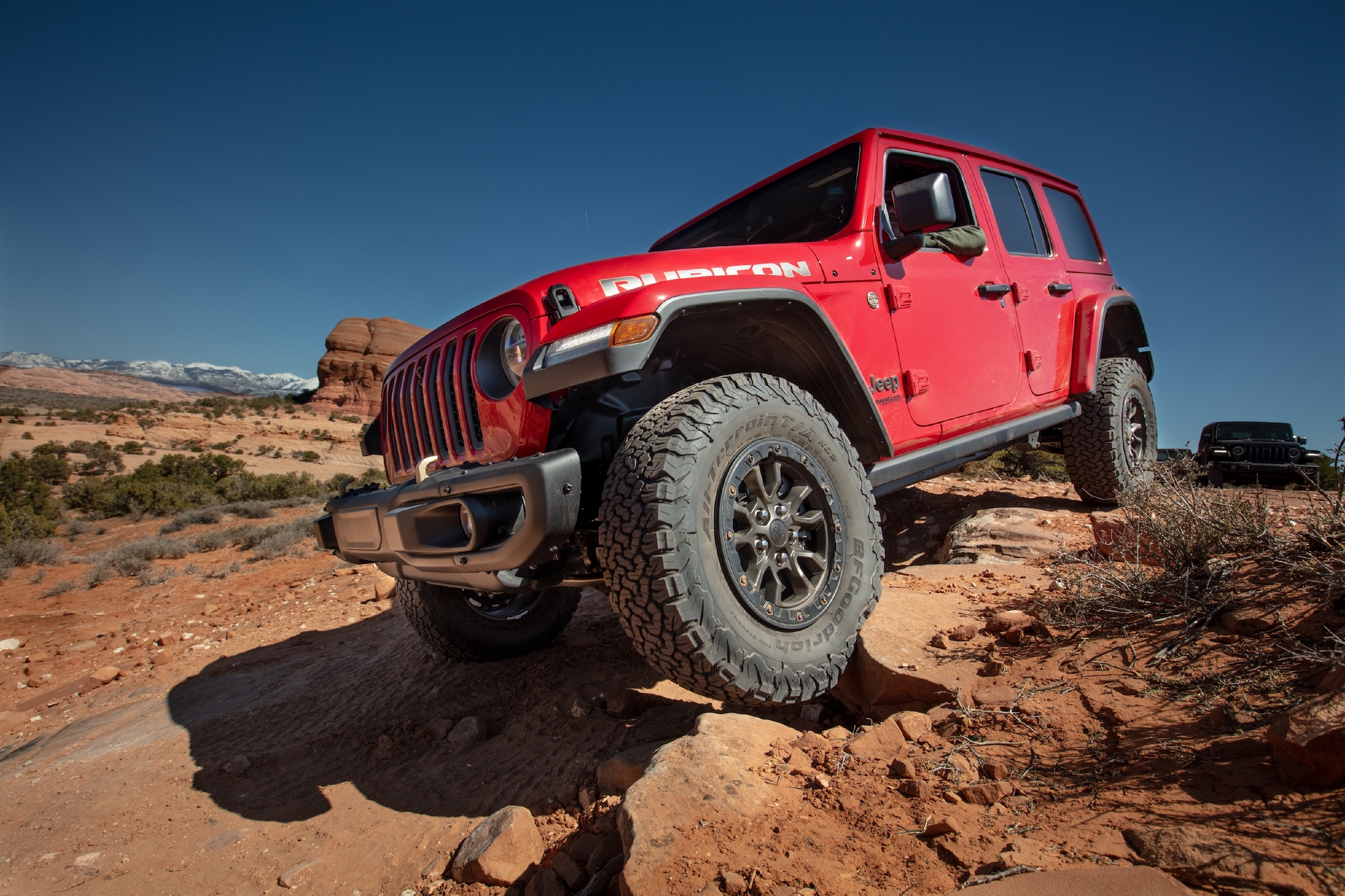 A red 2021 Jeep Wrangler Rubicon 392 SUV parked on rocks on the side of a hill