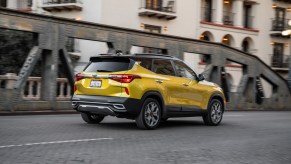 A yellow 2021 Kia Seltos parked on a city bridge