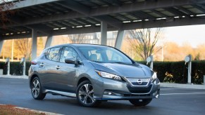 A gray 2021 Nissan Leaf hatchback EV parked at a charging station