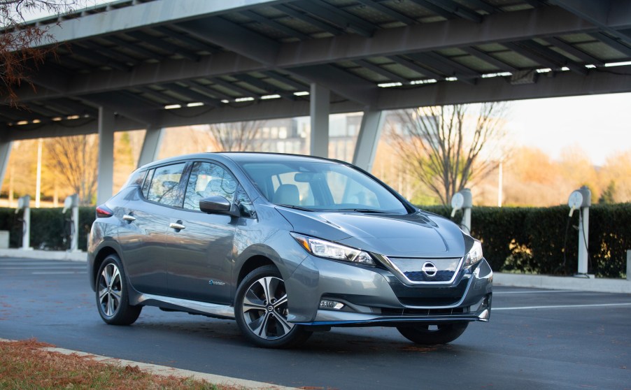 A gray 2021 Nissan Leaf hatchback EV parked at a charging station