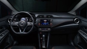 A 2021 Nissan Versa subcompact car's black front seats and dashboard