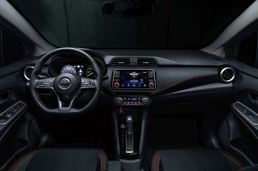 A 2021 Nissan Versa subcompact car's black front seats and dashboard