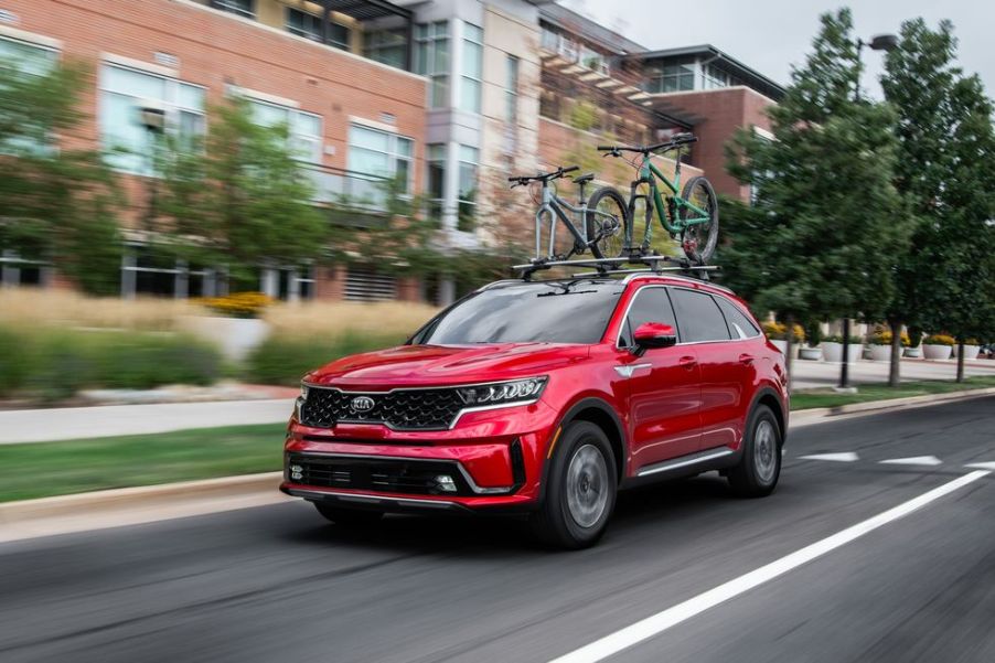 A red 2021 Kia Sorento Hybrid driving in the city