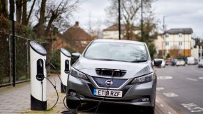 A gray nissan leaf on the charger