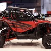 a red Honda Talon UTV on display at an indoor auto show