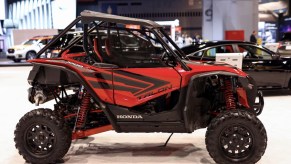 a red Honda Talon UTV on display at an indoor auto show