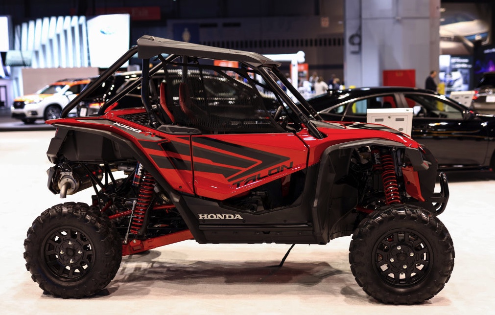 a red Honda Talon UTV on display at an indoor auto show