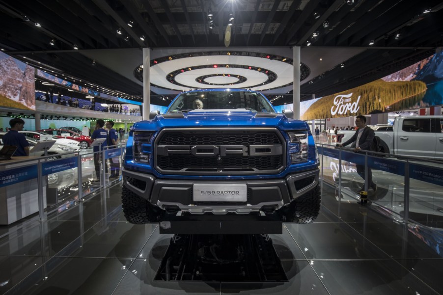 A blue Ford F-150 Raptor on display at an auto show