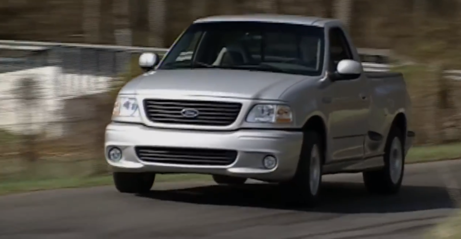 Silver Ford Lighting driving around a turn