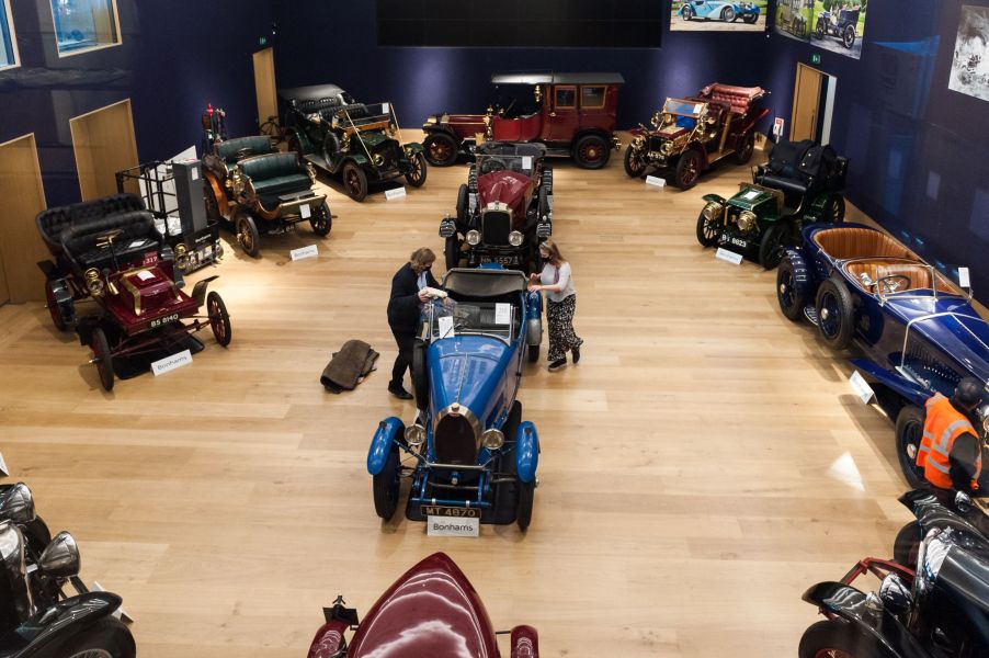 Two employees get some antique and vintage cars ready for an online Bonhams October 2020 auction