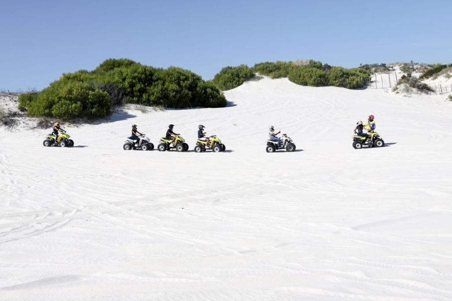 ATV riders traversing scenic sand dunes