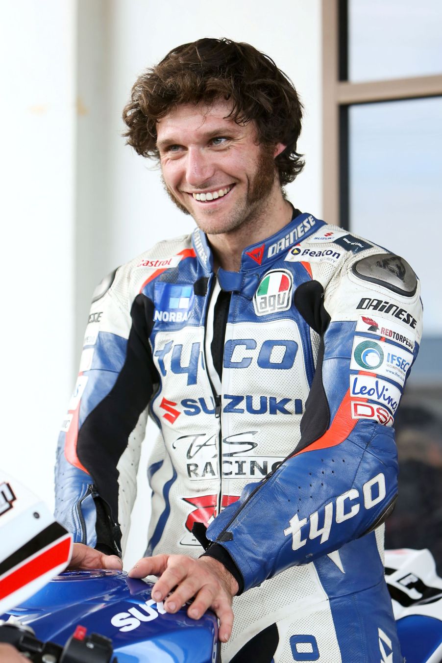 Guy Martin in a blue-white-and-red BMW-branded leather racing suit at the 2013 Cemetery Circuit Motorcycle Races in New Zealand