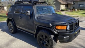 A modified black-Raptor-liner-sprayed 2007 Toyota FJ Cruiser parked in a cul-de-sac