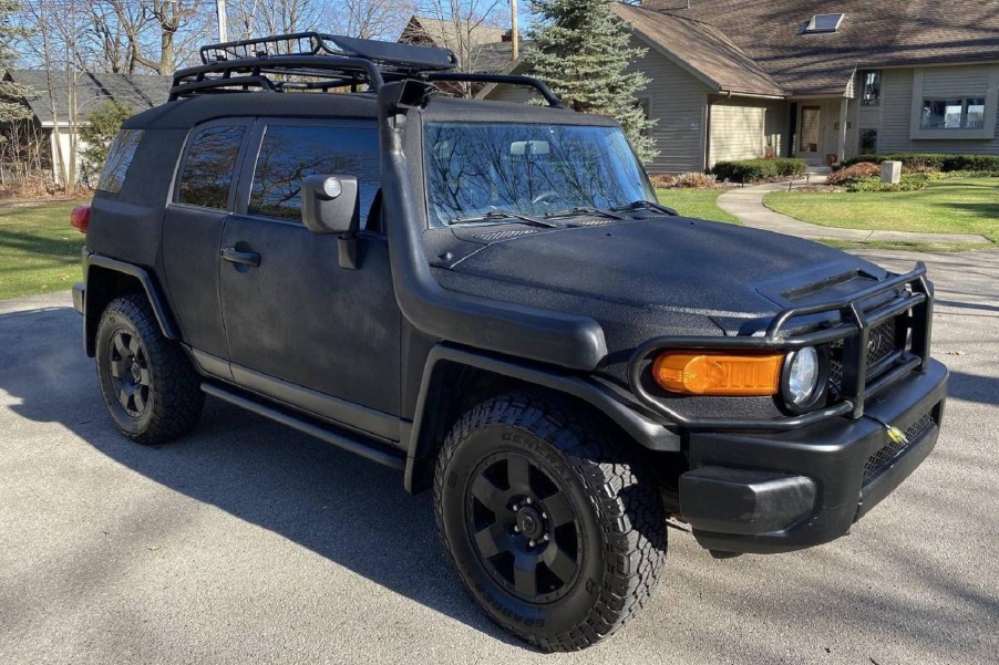 A modified black-Raptor-liner-sprayed 2007 Toyota FJ Cruiser parked in a cul-de-sac