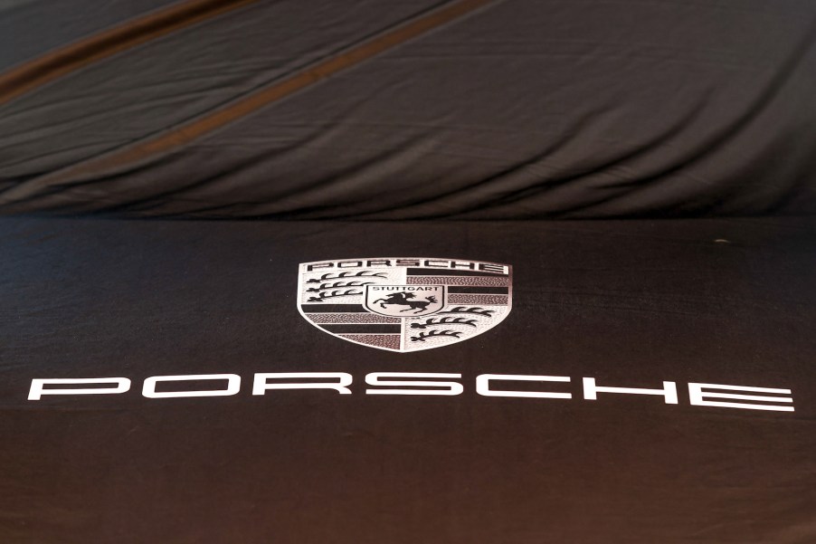 A Porsche logo sits on a covered automobile in the showroom at the Porsche Automobil Holding SE center in Hamburg, Germany, on Wednesday, August 5, 2020