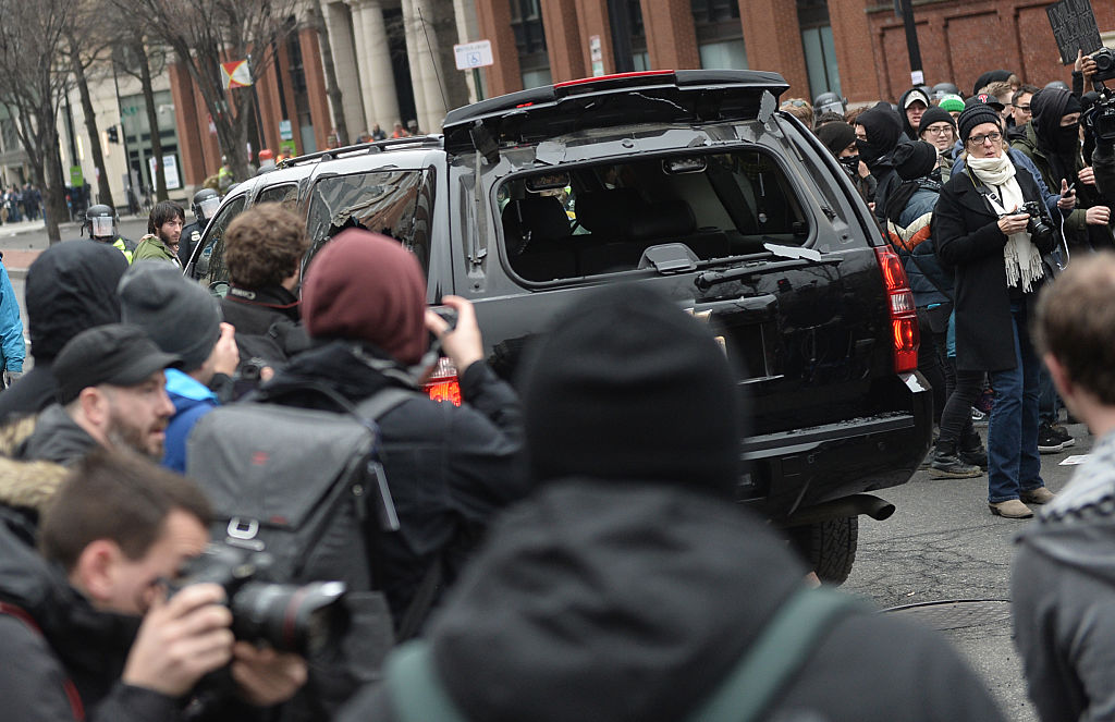 Police car driving through a crowd of protesters