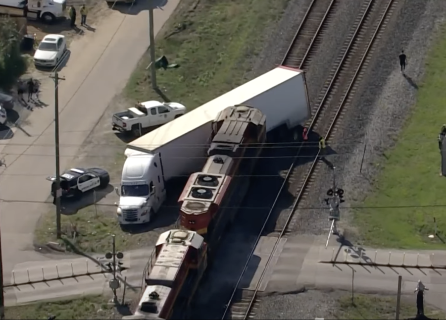 An image of a train crashing into a semi truck.