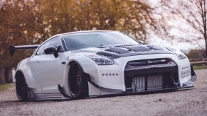 Starlite Limos' black-and-white R35 Nissan GT-R with a Rocket Bunny body kit parked in an English countryside manor garden