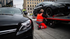 a man perpares a car for towing which a new study shows there are little state by state regulations in place to protect people from an unlawful tow