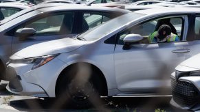 A worker parks a silver Toyota Motor Corp. Corolla vehicle at a Toyota Logistics Services Inc. automotive processing terminal at the Port of Los Angeles