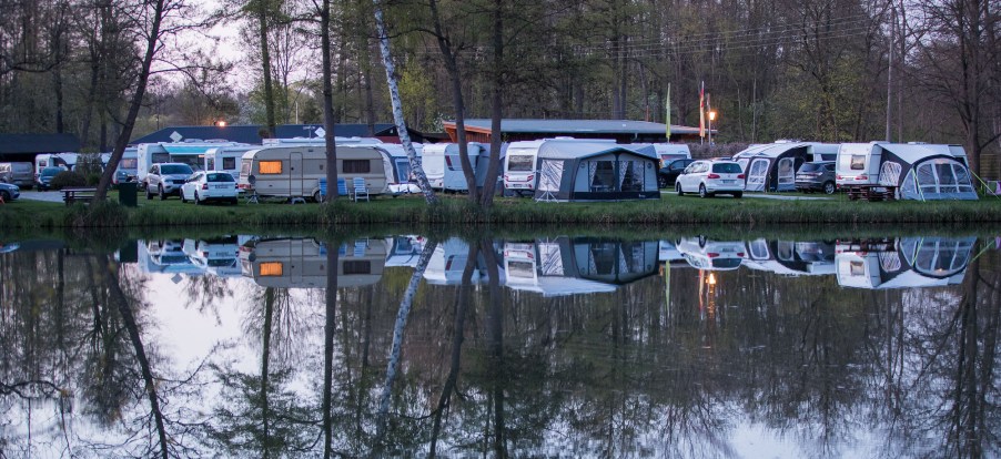 Travel trailers and other RVs at a camping site overlooking a lake