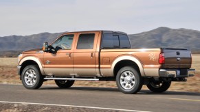 A 2011 Ford F250 diesel pickup truck being driven by a mountain range.