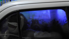 A person sleeping in a white car with fogged-up windows. Living in your car can be dangerous.