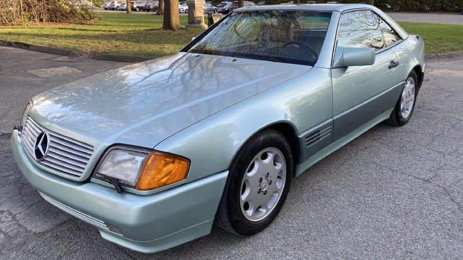 The front 3/4 view of a two-tone green 1991 Mercedes-Benz 300 SL in a park parking lot