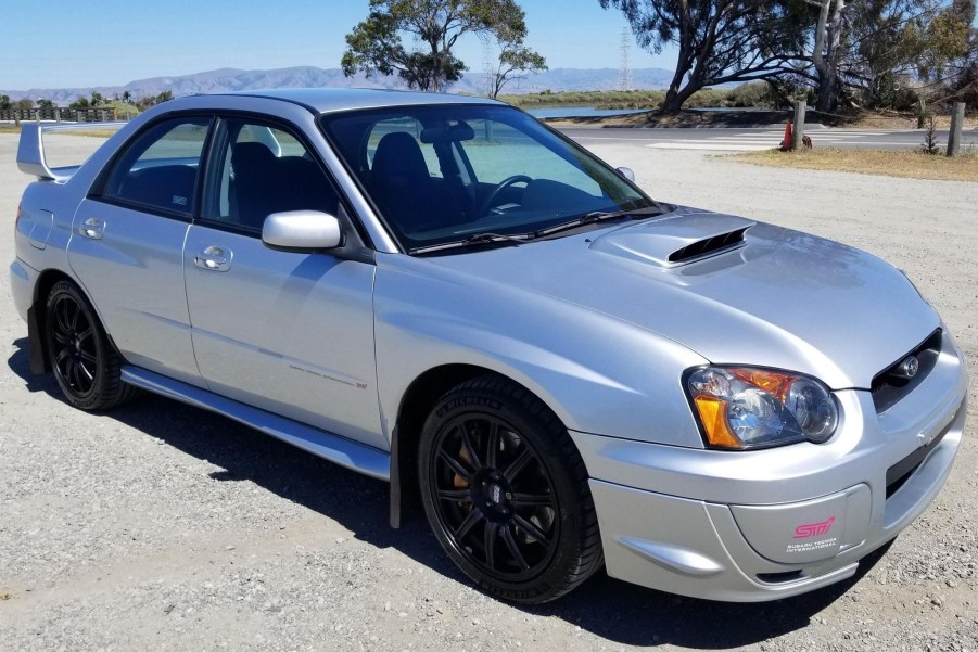 A silver 2004 Subaru Impreza WRX STi in a dirt parking lot