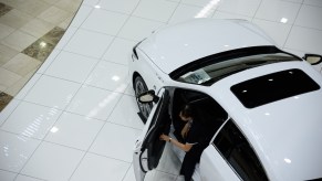 An employee comes out from a white 2019 Lexus ES 300h luxury car at the company's showroom in Toyota City, Aichi Prefecture, Japan, on Wednesday, June 12, 2019