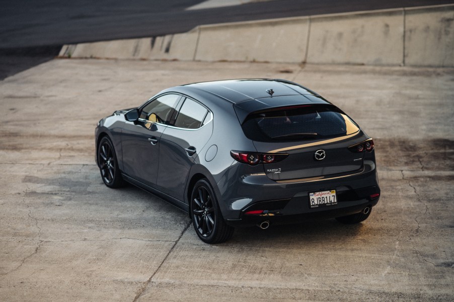 A dark-gray 2020 Mazda3 hatchback parked on a concrete slab