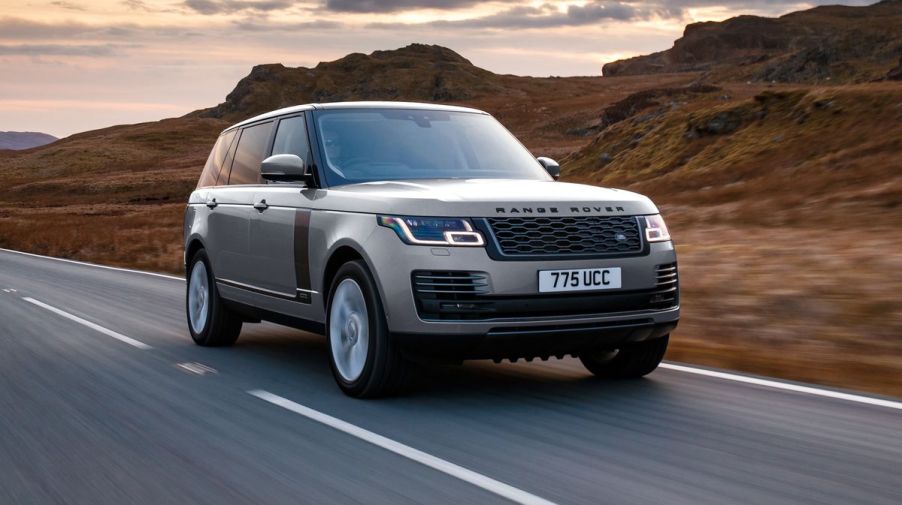 A 2020 Range Rover driving down the road in front of mountains