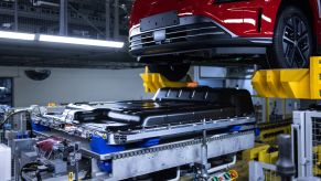 A red 2021 Hyundai Kona Electric body meets its battery pack during factory assembly