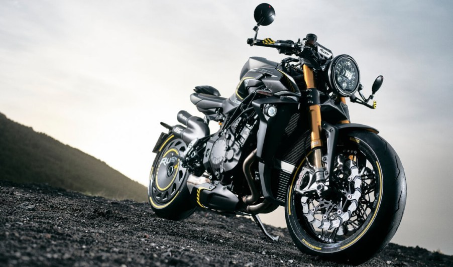 A low-angle front 3/4 view of a black-and-green 2021 MV Agusta Rush 1000 on black gravel