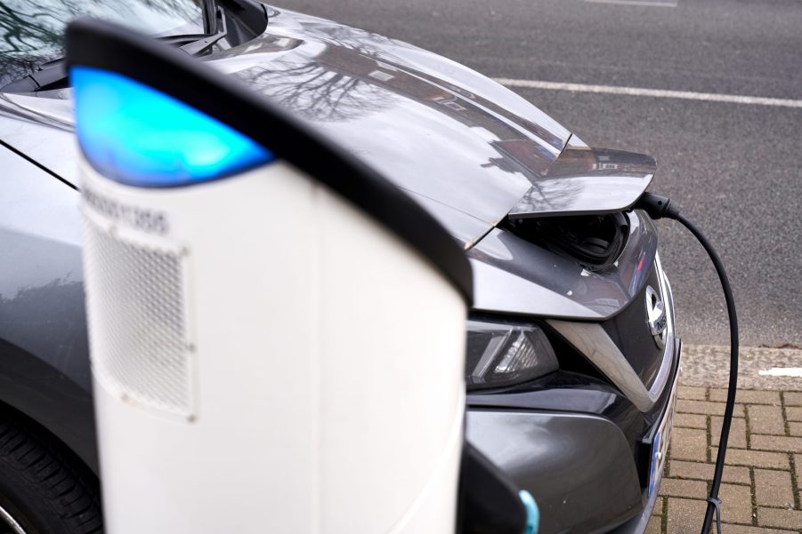 A gray 2021 Nissan Leaf EV sedan at a sharging station