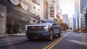 2022 Ford F-150 Lightning Platinum driving down a city street