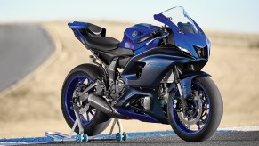 A blue-and-black 2022 Yamaha YZF-R7 on a rear-wheel stand on a desert racetrack