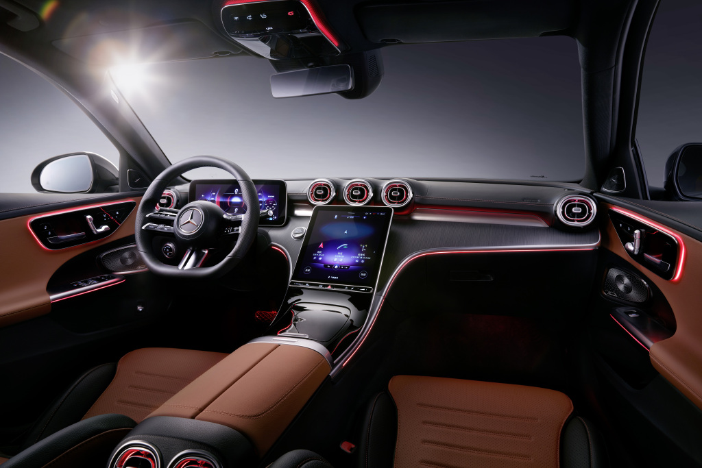 The interior of the Mercedes C-Class, with a large touch screen in the center and coffee-colored seats