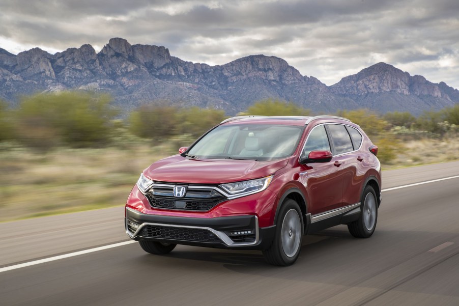 A red 2021 Honda CR-V Hybrid driving