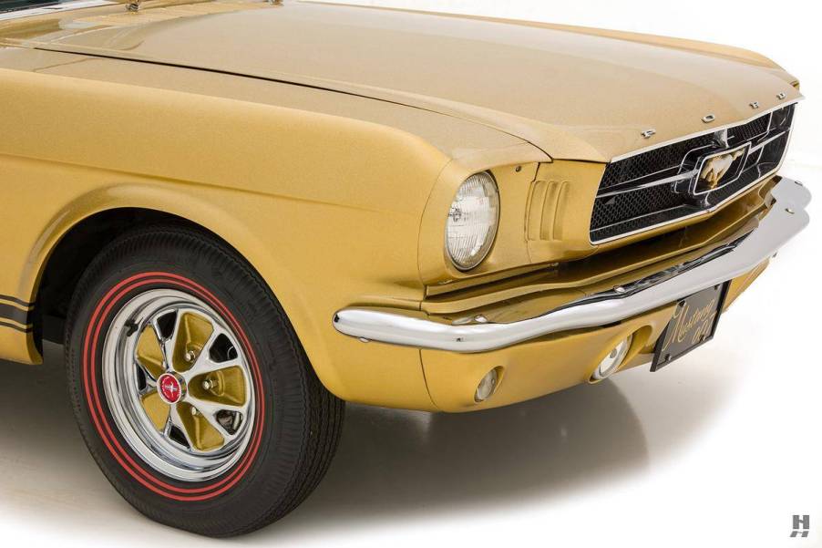 An image of a gold Ford Mustang parked inside of a photo studio.